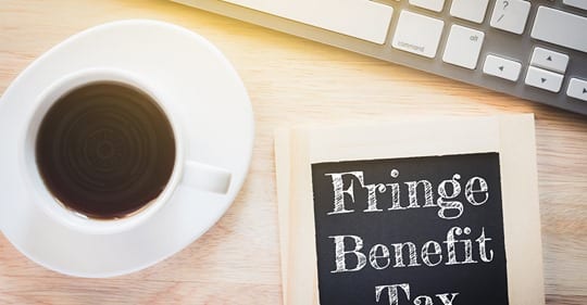 coffee cup and fringe benefit tax sign on desk